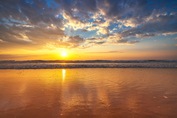 美丽的日出在海浪和热带岛屿的海滩上图片下载