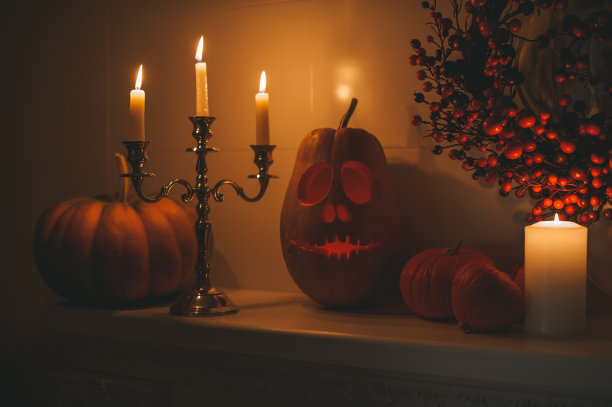 美丽的微笑的橙色雕刻南瓜杰克灯笼为万圣节假期在晚上的家庭内部图片下载