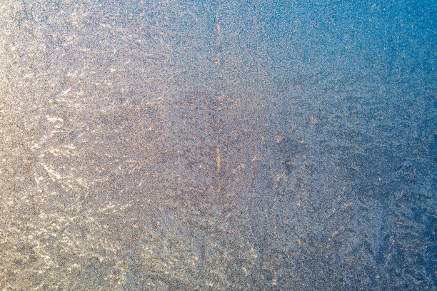 在寒冷的冬天，窗户玻璃上有结冰图案的结冰表面图片下载