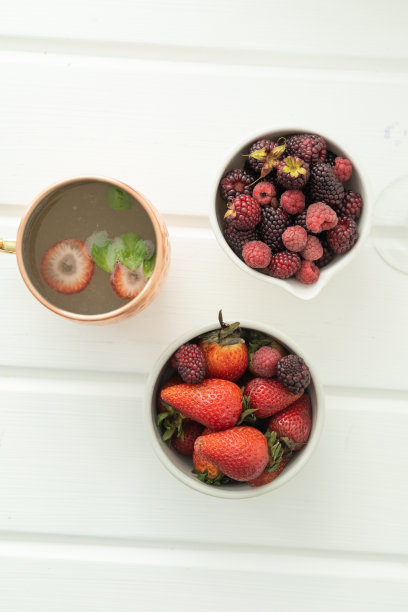 餐桌上点缀着新鲜的浆果、草莓和黑莓，搭配一杯健康的冷饮图片下载