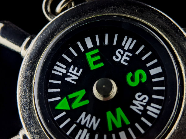 特写不锈钢罗盘钥匙扣在黑色背景。图片下载