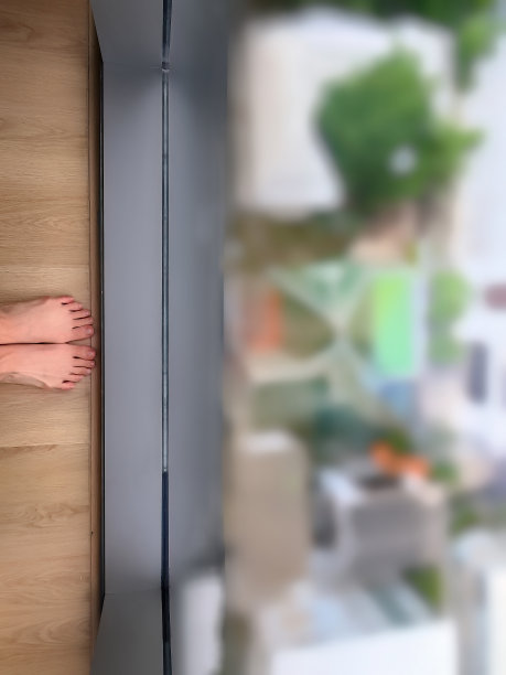 女性双脚站在现代建筑的全长玻璃窗旁，新冠肺炎检疫期间，在家工作，锁住，在建筑内，模糊的视野图片下载