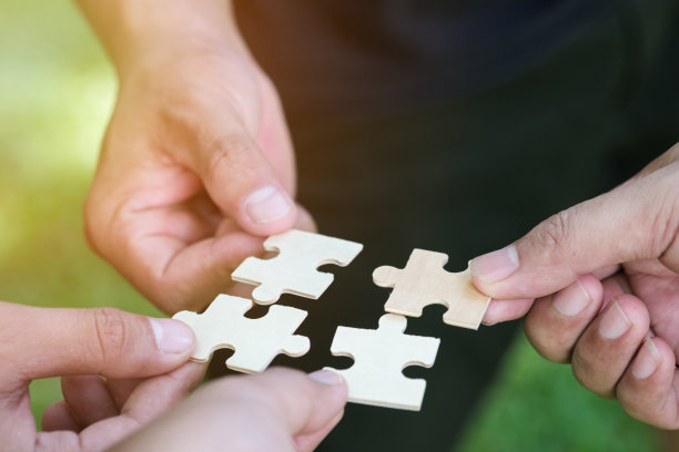 把拼图组合在一起的人。慈善事业,志愿者。团结,团队业务。团队合作和伙伴关系的概念。图片下载