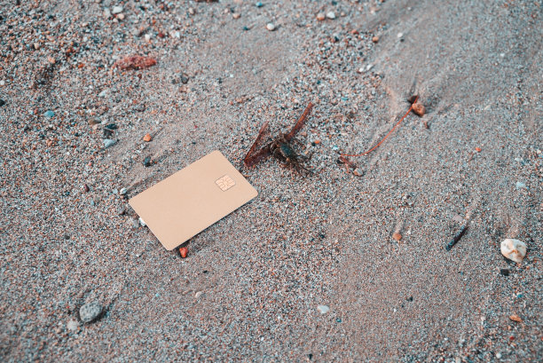 金色银行卡躺在希腊科孚岛Moraitika海滩的沙子上。为自然支付的概念和无限的可能性。副本的空间。高质量的照片图片下载