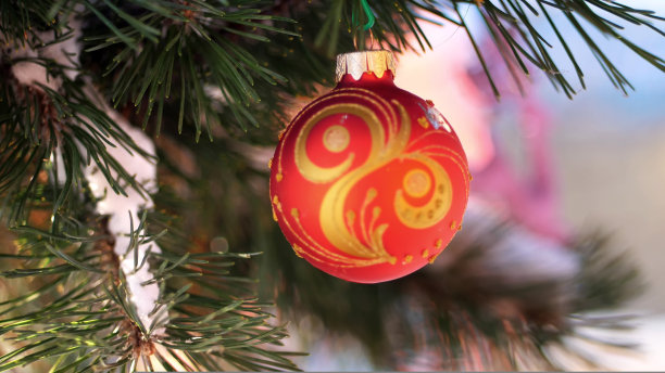 特写，圣诞玩具挂在白雪覆盖的圣诞树树枝上。冬天，结霜，下雪，晴天。图片下载