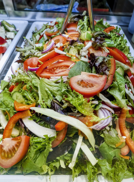 蔬菜拌沙拉由生菜、西红柿、洋葱和甜椒组成，装在托盘里出售图片下载