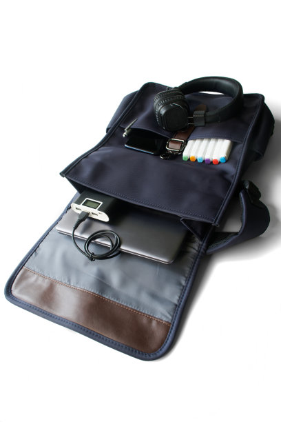 时尚男士的蓝色城市背包，笔记本电脑，充电宝，耳机，手机和白色标记。创意和设计，学习和生活方式，旅行和旅行的小工具。图片下载