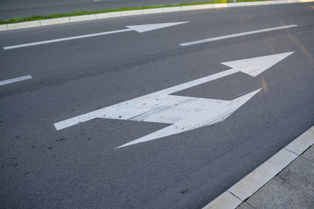 近景:画在道路上表示右转或直走的路标的近景制定交通规则的工具。路标。图片下载
