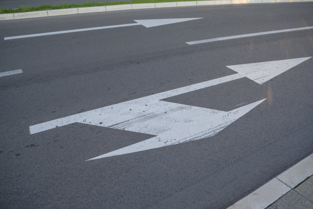 近景:画在道路上表示右转或直走的路标的近景制定交通规则的工具。路标。图片下载