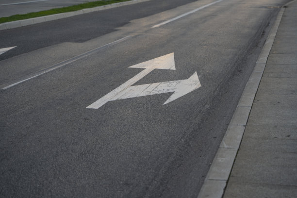 近景:画在道路上表示右转或直走的路标的近景制定交通规则的工具。路标。图片下载