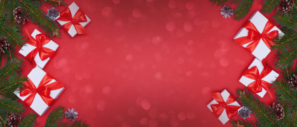 云杉，冷杉枝，红色浆果，礼品盒在红色背景。帧边界。圣诞新年作文背景。圣诞灯。空间的文本。图片下载
