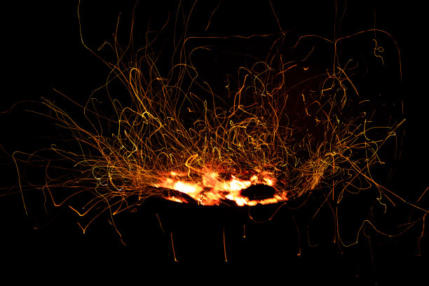 篝火火焰火花长时间曝光孤立在黑色背景。火焰在黑色背景上长时间曝光时闪闪发光图片下载