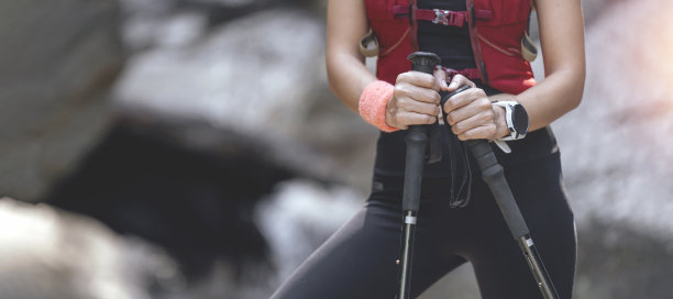 裁剪拍摄的女性跑步者手持杆北欧行走，模糊的背景和复制空间。图片下载