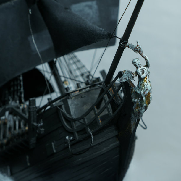 海盗船模型由胶合板，与海盗水手的微型人物，孤立在白色背景图片下载