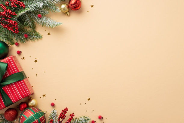 圣诞夜的概念。俯视图的照片，目前的盒子与弓金色的红色和绿色的小饰物球槲寄生浆果松枝在雪和闪亮的彩色纸屑孤立的米色背景与copyspace图片下载