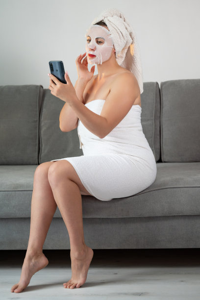 使用化妆面膜的面部皮肤清洁程序，一名女子在网上打电话。图片下载