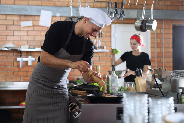 专业厨师在餐厅厨房灶台上烹饪肉类图片下载