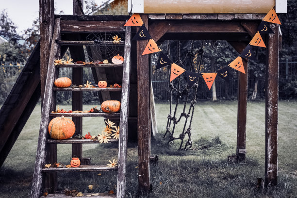 万圣节设计庭院与干燥的落叶。在秋天的时候，房子美丽的木制门廊和南瓜。图片下载