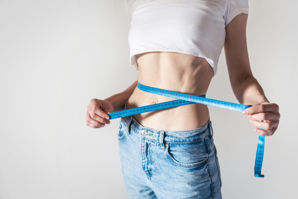 女人用蓝色卷尺检查腰围图片下载