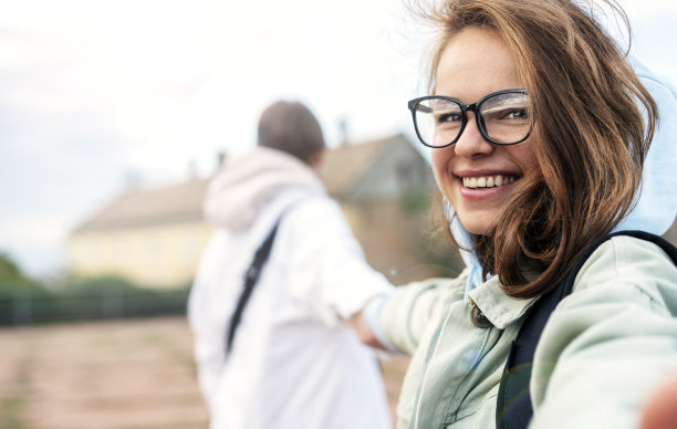 一对情侣在自拍，戴眼镜的女人看着相机微笑。图片下载