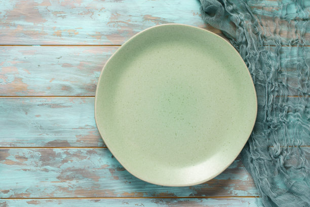 空空的绿盘子和纱布餐巾放在破旧的蓝木桌上图片下载