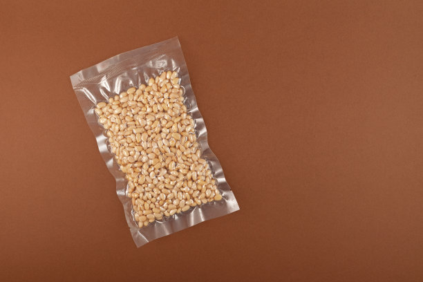 透明真空包装的雪松坚果。棕色背景，复制空间。剥松子图片下载