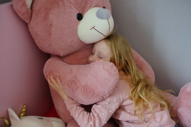 女孩抱着她的玩具。快乐的时刻。爱的背景。熊和女孩图片下载