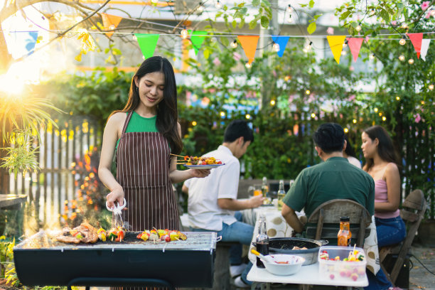 可爱的亚洲女人为一群朋友烧烤。图片下载