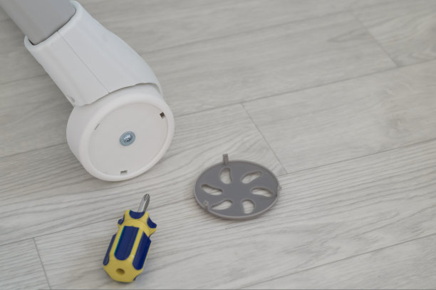 把螺丝刀拧在儿童家具的塑料轮子上。轮总成。组装婴儿高脚椅。有选择性的重点图片下载