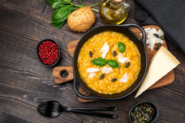 意大利烩饭配南瓜和南瓜子，帕尔马干酪和罗勒。米兰烩饭加藏红花。意大利菜秋季季节性菜单图片下载