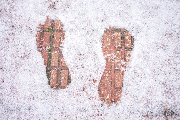积雪覆盖的人行道上脚印的高角度镜头图片下载