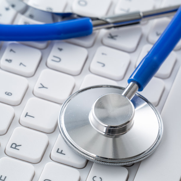 笔记本电脑键盘上的蓝色听诊器，医疗设计理念。图片下载