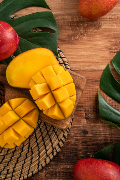 深色木桌背景上有新鲜的芒果叶子。图片下载