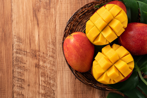 深色木桌背景上有新鲜的芒果叶子。图片下载