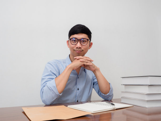 积极的商人戴眼镜自信地坐在工作场所图片下载