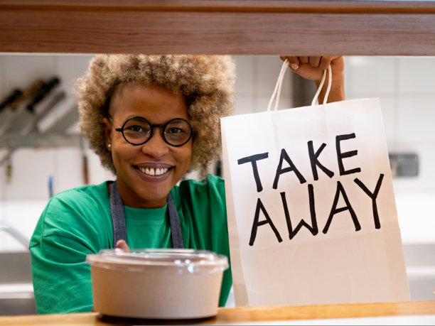 快乐的非裔美国女性在外卖餐厅工作。外卖图片下载