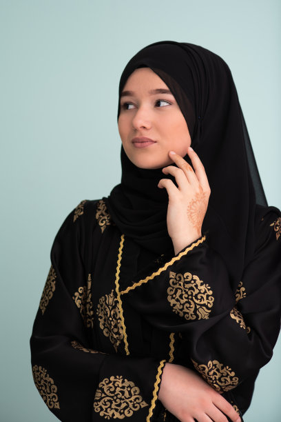 美丽的穆斯林妇女在时尚的服装与头巾隔离在现代青色背景代表现代伊斯兰教和斋月kareem的概念图片下载