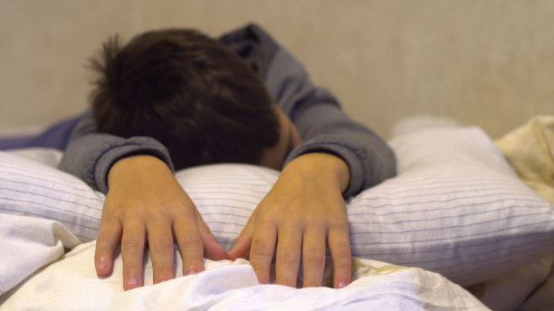 男孩伸出双手。躺在床上图片下载