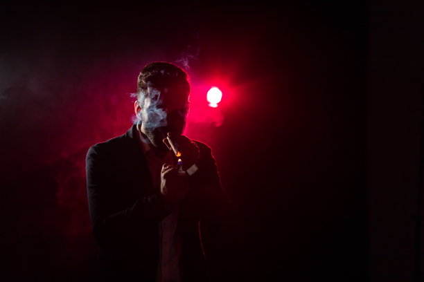 粉红色背景上吸烟的男人的照片。图片下载