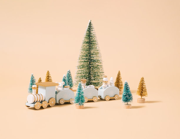 金色背景上有彩色玩具火车的圣诞树。图片下载