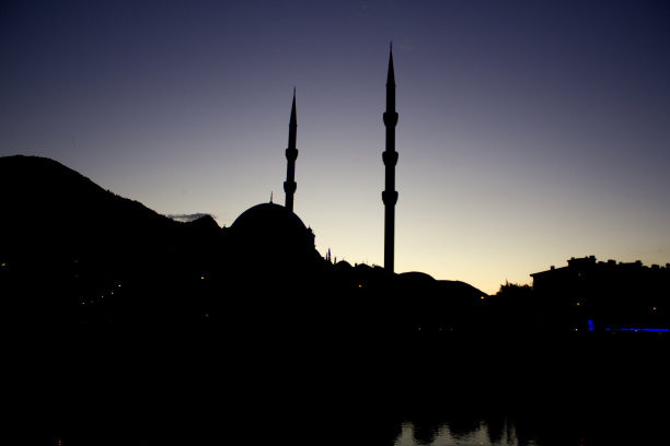 黄昏时的山、清真寺和联排别墅的剪影图片下载