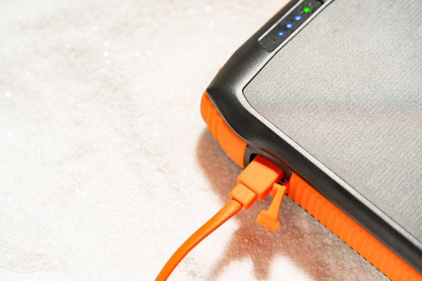 装有太阳能电池板的便携式充电宝躺在沙滩上，在旅行中积累太阳能。可替代生态能源生产。图片下载
