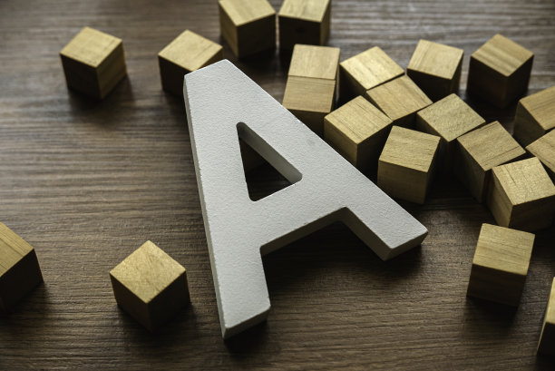 棕色木制背景上的木制字母A。图片下载