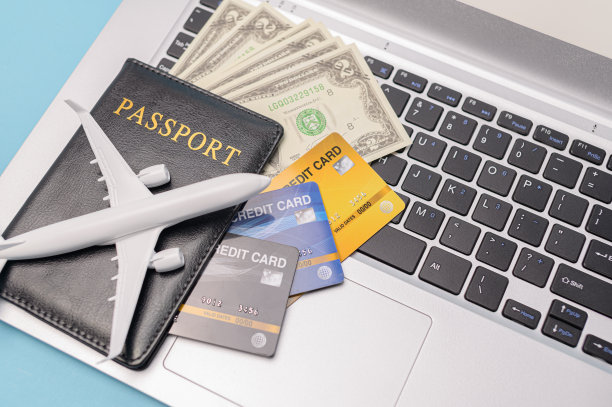 护照，信用卡，美钞，笔记本电脑上的飞机——旅行的概念图片下载