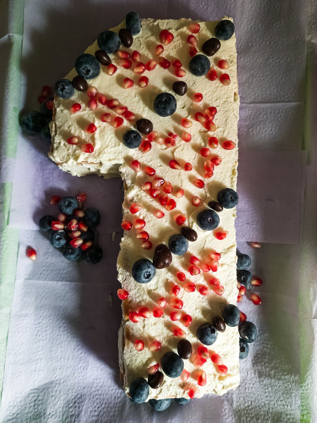 蛋糕中加入鲜奶油、蓝莓和石榴，做成一号蛋糕的形状。图片下载