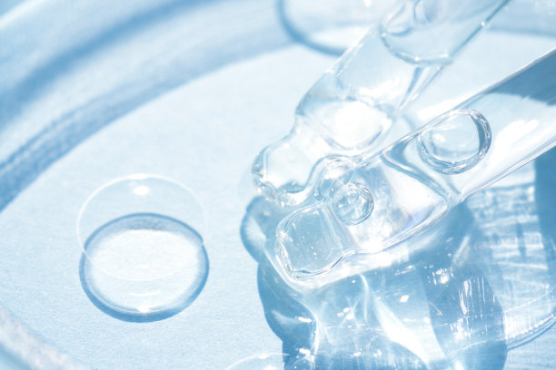 移液管与透明化妆品液体或面部精华在蓝色背景。水化物或美容油的质地，漂亮的处理。有选择性的重点图片下载