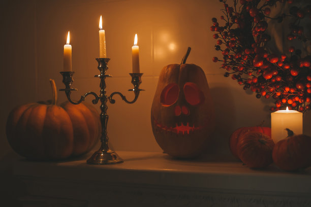 美丽的微笑的橙色雕刻南瓜杰克灯笼为万圣节假期在晚上的家庭内部图片下载