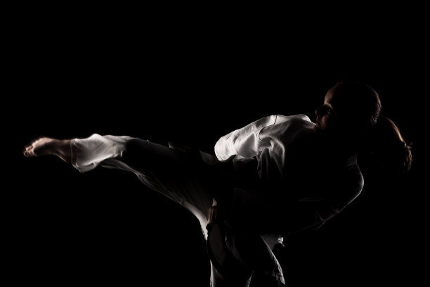 年轻的女孩练习空手道。在黑色背景下穿着和服的孩子。图片下载