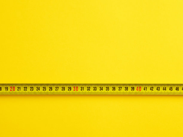评估或测量尺寸概念。带测量在黄色背景与复制空间。图片下载