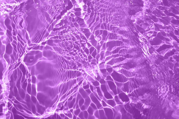 离焦模糊透明的紫色色彩清澈平静的水面纹理带有水花、气泡。闪闪发光的紫色水波纹背景。游泳池的水面。紫色泡泡水闪闪发光。图片下载